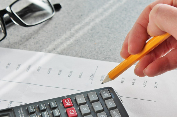 Exposição do banco de contabilidade com lápis de mão e calculadora
 - Foto, Imagem