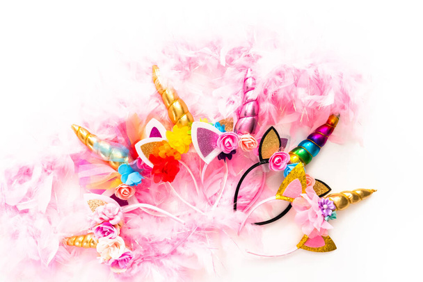 Flat lay. variety of unicorn headbands with pink feathers on a white background. - Photo, image