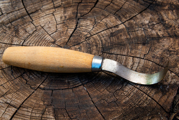 Cuchillo de talla de madera estilo sueco enganchado sobre fondo de madera, para tallar en madera y hacer cucharas, hobby o pasatiempo. - Foto, Imagen