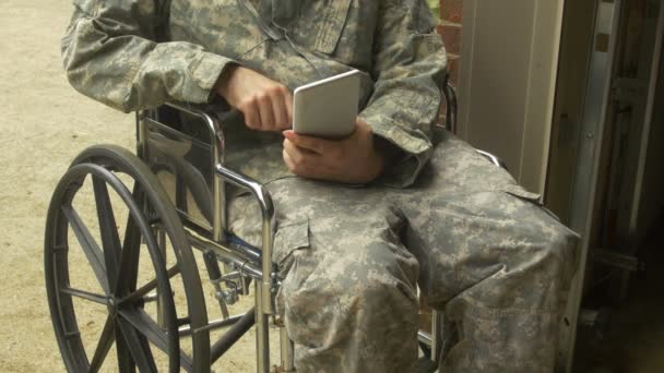 Tekerlekli sandalyedeki asker. BDU takıyor, dokunmatik ped kullanıyor. - Video, Çekim