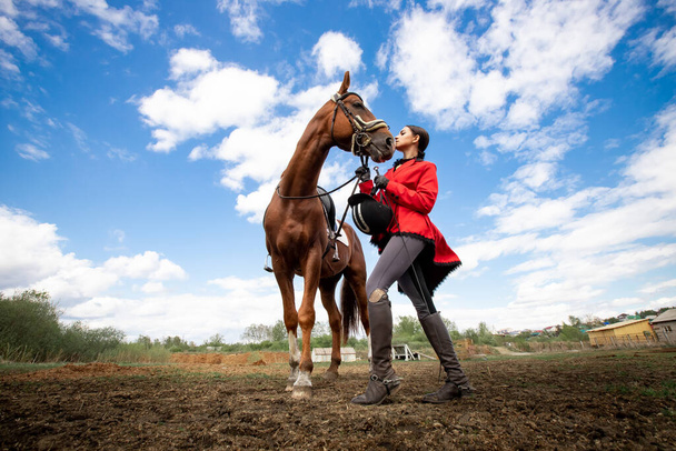 馬術スポーツ、若い女性のジョッキー茶色の馬に乗っている - 写真・画像