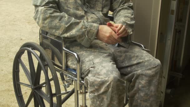 Militaire man nerveus in een rolstoel buiten - Video
