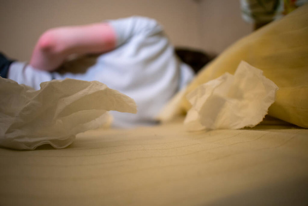 Молодой человек в белой рубашке лежит в постели больной грязными тканями - Фото, изображение