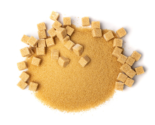Brown sugar sand and cubes isolated on white background. Pile of raw unrefined cane sugar, sweetener heap top view - Photo, Image