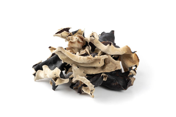 Dry black fungus, tree ear or wood ear mushroom isolated on white background. Dried auricularia polytricha also known as cloud ear, black mushroom, jelly fungus or cloud ear fungus - Photo, Image