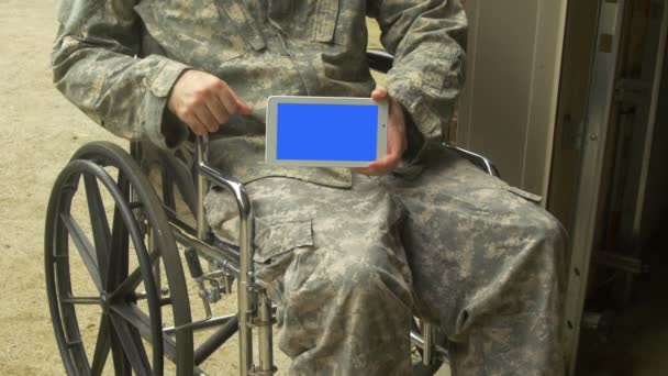 exército homem segurando um touchpad keyable em uma cadeira de rodas - Filmagem, Vídeo