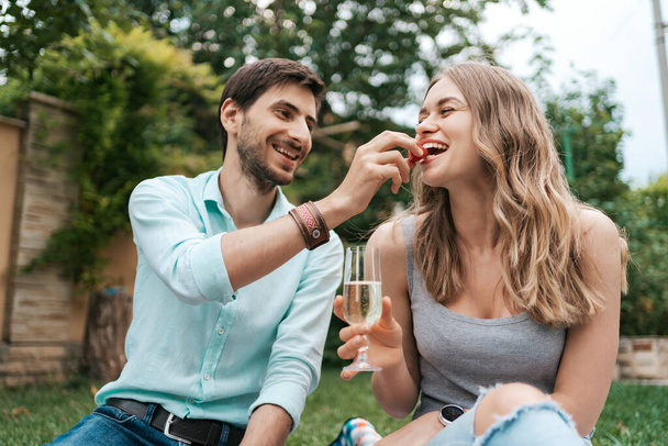 Пара п'є ігристе вино з полуницею
 - Фото, зображення