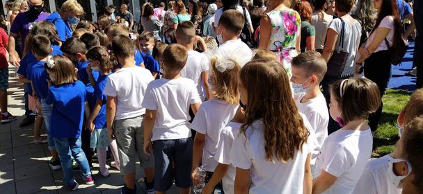 Sremska Mitrovica, Serbia, 01 September 2020 Children go to school. September 1 during the coronavirus pandemic. Knowledge Day during the Covid-19 pandemic. First graders stand in pairs. - Foto, afbeelding