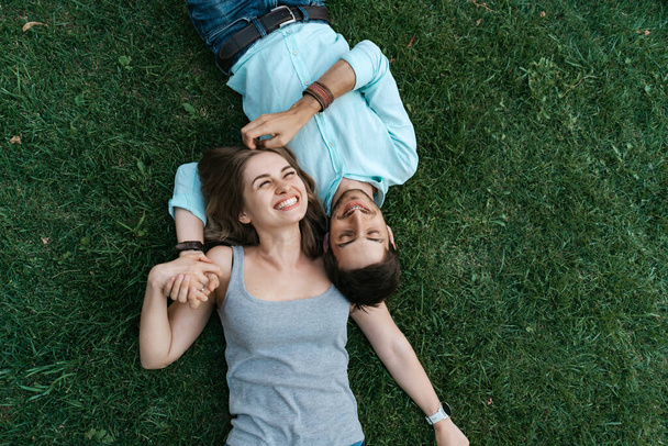 Happy couple lying on the grass - Foto, afbeelding