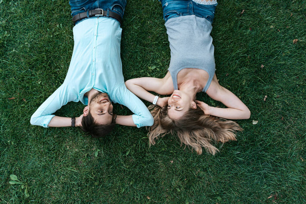 Happy couple lying on the grass - Zdjęcie, obraz