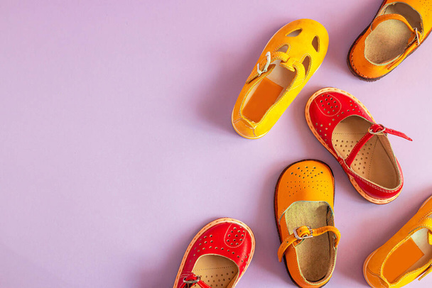 Élégantes nouvelles chaussures jaunes et rouges sur un fond pastel coloré avec copyspace, vue de dessus, position plate - Photo, image