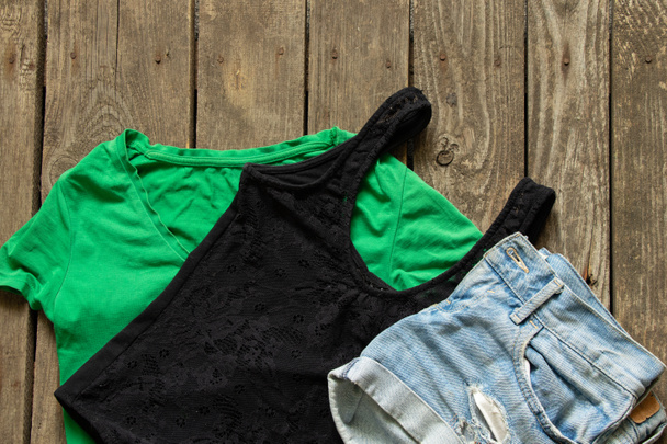 shorts et t-shirts femme vert et noir sur fond bois close-up, vêtements femme - Photo, image