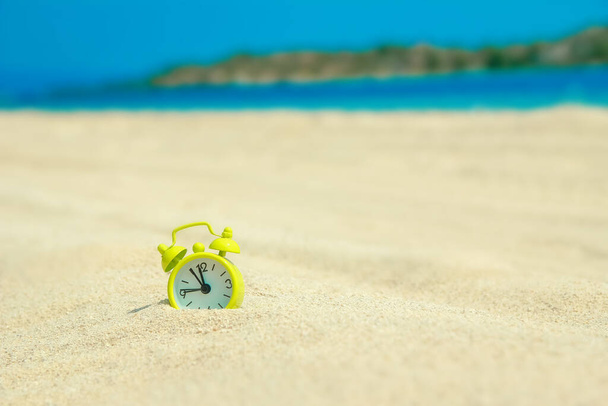 beautiful alarm clock in the sand by the sea background - Foto, Imagen