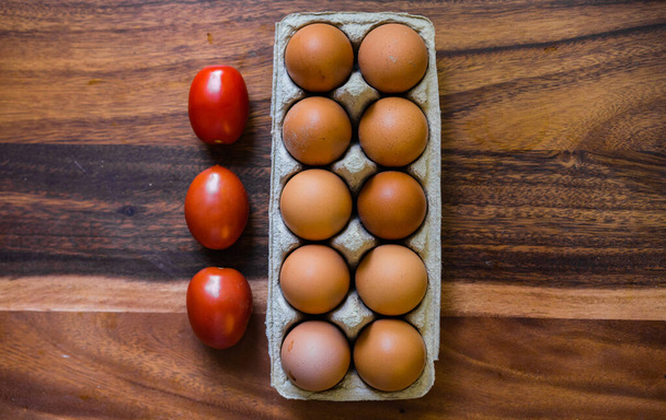 rauwe eieren in een eierschaal op een houten keukentafel - Foto, afbeelding