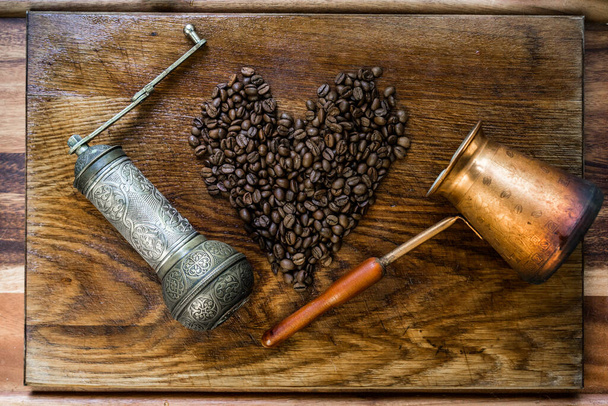 トルコのコーヒーコンセプト。銅コーヒーポット(Cezve) 、ヴィンテージコーヒーグラインダー、カップ、暗い木製の背景にコーヒー豆。最上階だ。水平. - 写真・画像