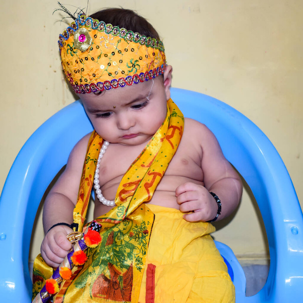 Cute Indian Kid dressed up as little Lord Krishna on the occasion of Radha Krishna Janmastami Festival in Delhi India during day time - Photo, Image