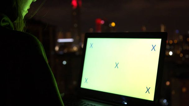 Woman using laptop on terrace at night - Photo, Image