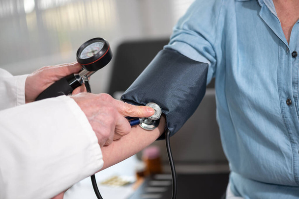 Médico que mede a pressão arterial de uma paciente do sexo feminino - Foto, Imagem