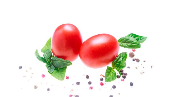 Tomaten mit grünen Basilikumblättern und trockenem Paprika auf weißem Hintergrund isolieren. Kopierraum, Nahaufnahme, - Foto, Bild