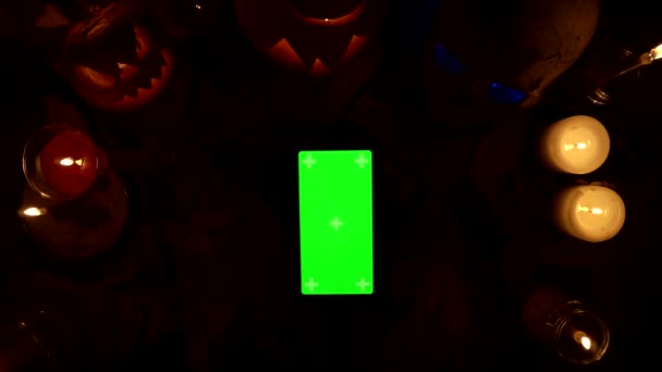 Uso de smartphone vertical con pantalla verde en el fondo de la decoración de Halloween - Metraje, vídeo
