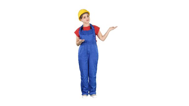 Mature engineer woman presenting a product pointing to side on white background. - Photo, Image