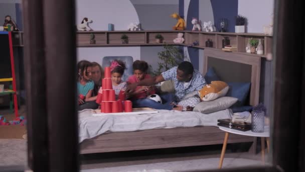 Объединенная смешанная расовая семья с детьми, играющими дома - Кадры, видео