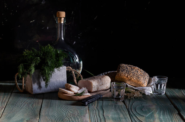Still life. Lard, homemade vodka, green onions, dill and bread on a wooden table close-up (Ukrainian and Russian national appetizer) - Fotoğraf, Görsel