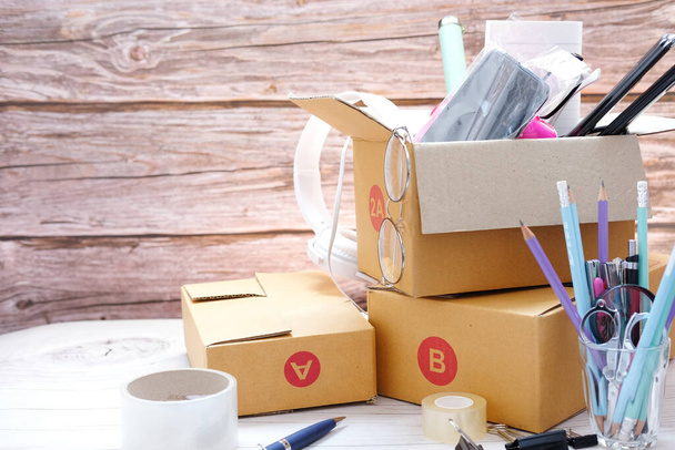 Příprava balíků pro zásilky zákazníkům na stole v domácí kanceláři, obaly z kartonové krabice na stůl. Online prodej, e-commerce koncept - Fotografie, Obrázek