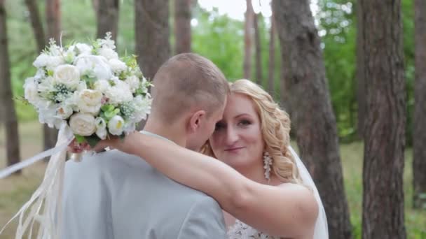 Linda noiva e noivo abraçando e beijando na floresta de verão. - Filmagem, Vídeo