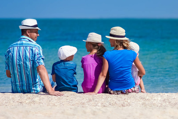 Щасливі батьки сім'ї з дітьми біля моря на природі подорожують
 - Фото, зображення