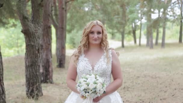 Νύφη με γαμήλιο μπουκέτο στο πράσινο δάσος του καλοκαιριού. - Πλάνα, βίντεο