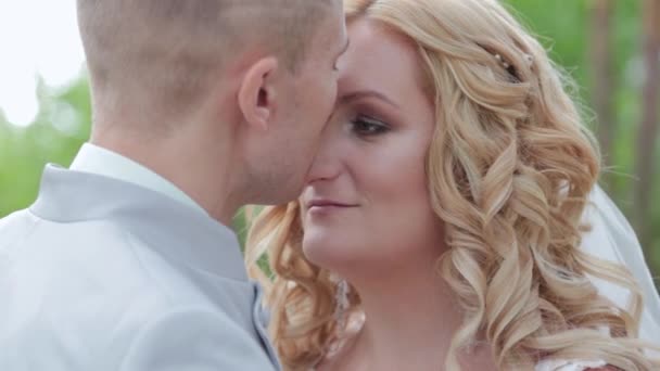 Gorgeous bride and groom hugging and kissing in summer forest. - Footage, Video