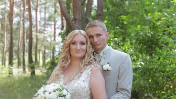 Wunderschöne Braut und Bräutigam umarmen und küssen sich im Sommerwald. - Filmmaterial, Video