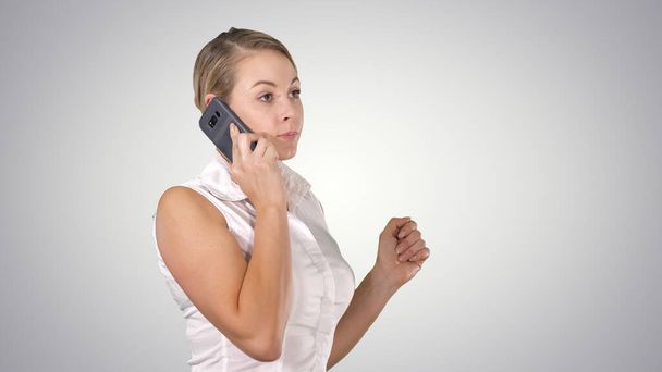 Charming business woman calling with cell telephone while standing on gradient background. - Foto, Bild