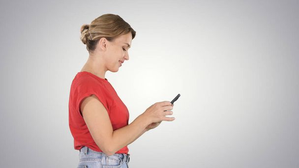 Pretty woman using cell phone on gradient background. - Фото, зображення