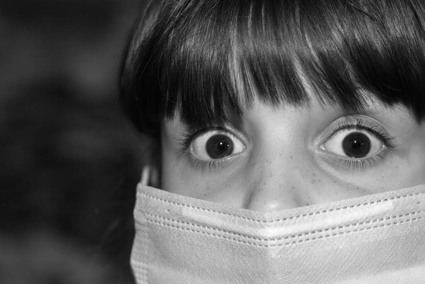 Miedo a ser infectado con el virus de la corona Covid-19.Gran retrato de un niño con ojos marrones y una máscara médica protectora en la cara. - Foto, Imagen