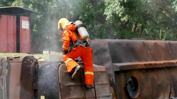 Palomies taistelee palo liekki suojaa omaisuutta. Palomies käyttää kypärää, kehon turvapuku yhtenäinen suojaa palo toimintaa. Pelastuskoulutus palonsammuttimien vaarallisissa paloissa - Materiaali, video
