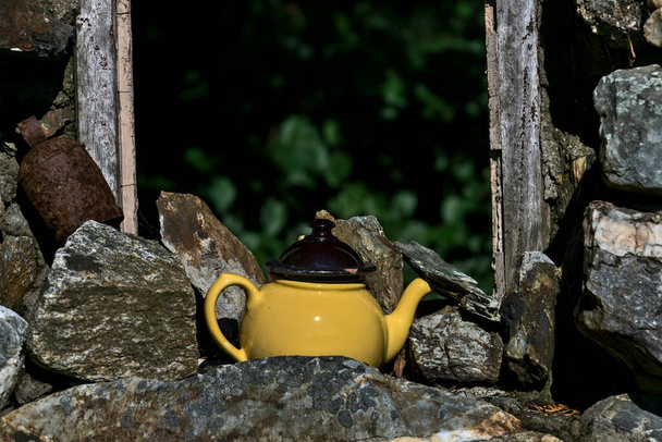 Old ceramic teapot. Antique teapot beside old stone wall and window frame as a sign of Irish hospitality, County Wicklow, Ireland - Photo, Image