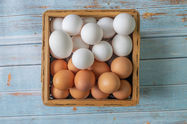 vista superior de huevos marrones y blancos orgánicos en cesta - Foto, Imagen