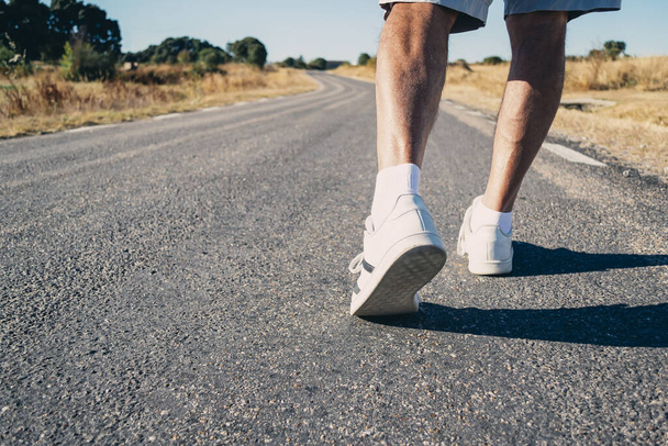 Close-up of an elderly man's legs walking down the road. Concept of vitality - Fotó, kép