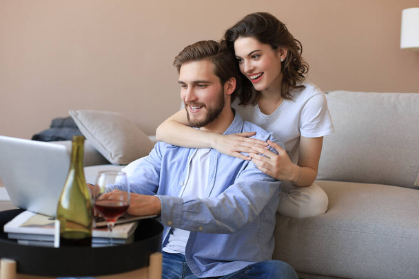 Boldog pár ül, pihentető padlón a nappaliban, használja laptop online vásárlás együtt, filmet nézni - Fotó, kép