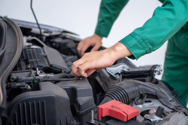 Professional mechanic hand providing car repair and maintenance service in auto garage. Car service business concept. - Foto, imagen
