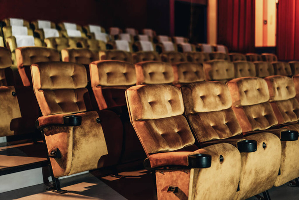 Een rij gele stoelen met popcorn op stoel in de bioscoop - Foto, afbeelding