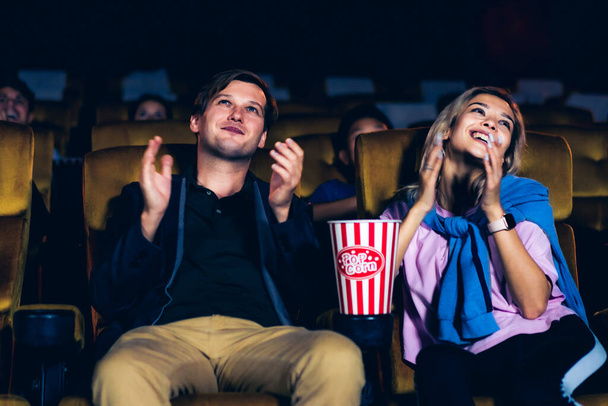 Группа зрителей счастливо и весело смотрит кино в кинотеатре. Концепция группового отдыха и развлечений. - Фото, изображение