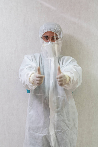 Lékař v obleku PPE, obličejové masce a obličejovém štítu v nemocničním oddělení chráněn před infekcí Coronavirem a Covid-19 . - Fotografie, Obrázek