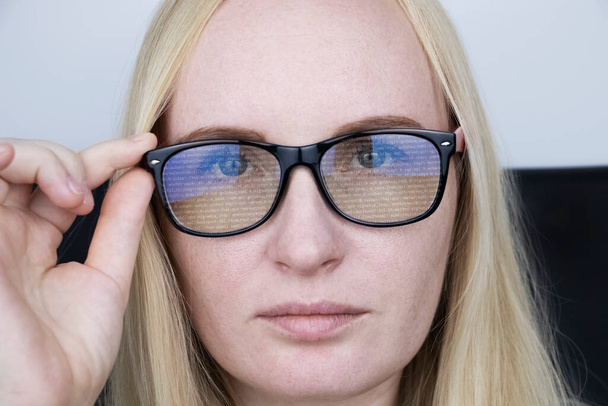 プログラマーの女の子の眼鏡は、コードの移動行を反映します。プログラミング、アプリケーション、サイトなどの開発。ソフトウェア開発コンセプト - 写真・画像