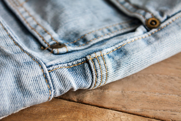Close up of blue jeans ,Blue Jeans texture on wooden floor - Фото, изображение