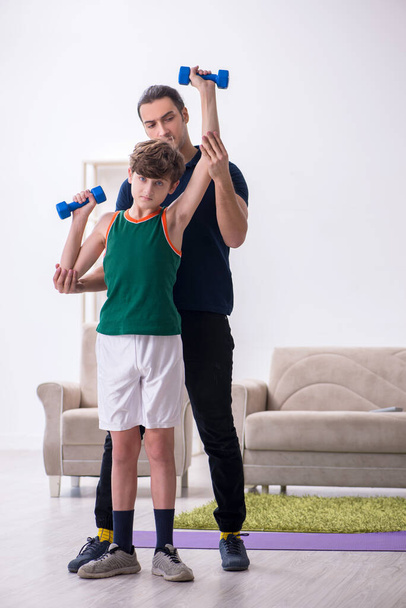 Батько і син займаються спортом в приміщенні
 - Фото, зображення
