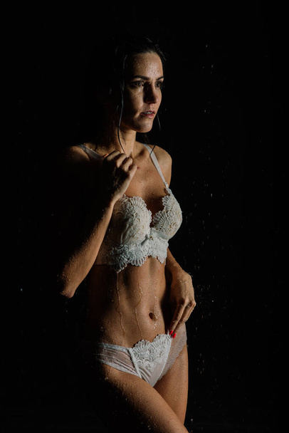 Młoda seksowna kobieta w białej bieliźnie. Studio wodne zdjęcie. - Zdjęcie, obraz