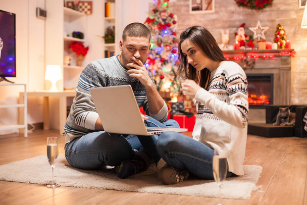 Happy couple looking for christmas gifts on internet - Photo, Image